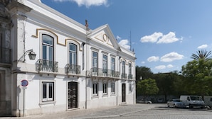 En historisk byggnad med klassisk arkitektur, kännetecknad av en symmetrisk fasad, många fönster och en balkong.