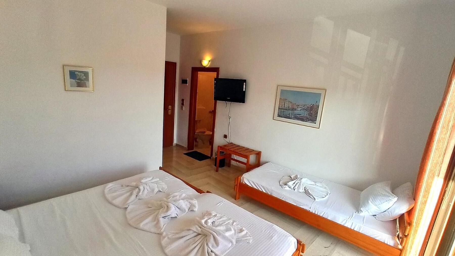 Une chambre d’hôtel avec deux lits, une télévision et une petite table.