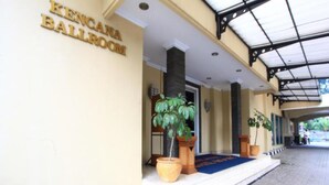 L’entrée d’un hôtel, avec une enseigne indiquant « SALLE DE BAL KENICANA ».