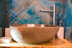 A stone basin sink with a modern faucet in a bathroom with blue-tiled walls. - La Casa a Mare (Messina)