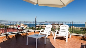 A terrace with white chairs and a table, overlooking a scenic view of the sea and buildings. - Bed & Breakfast Marina D'Aspra (Bagheria)