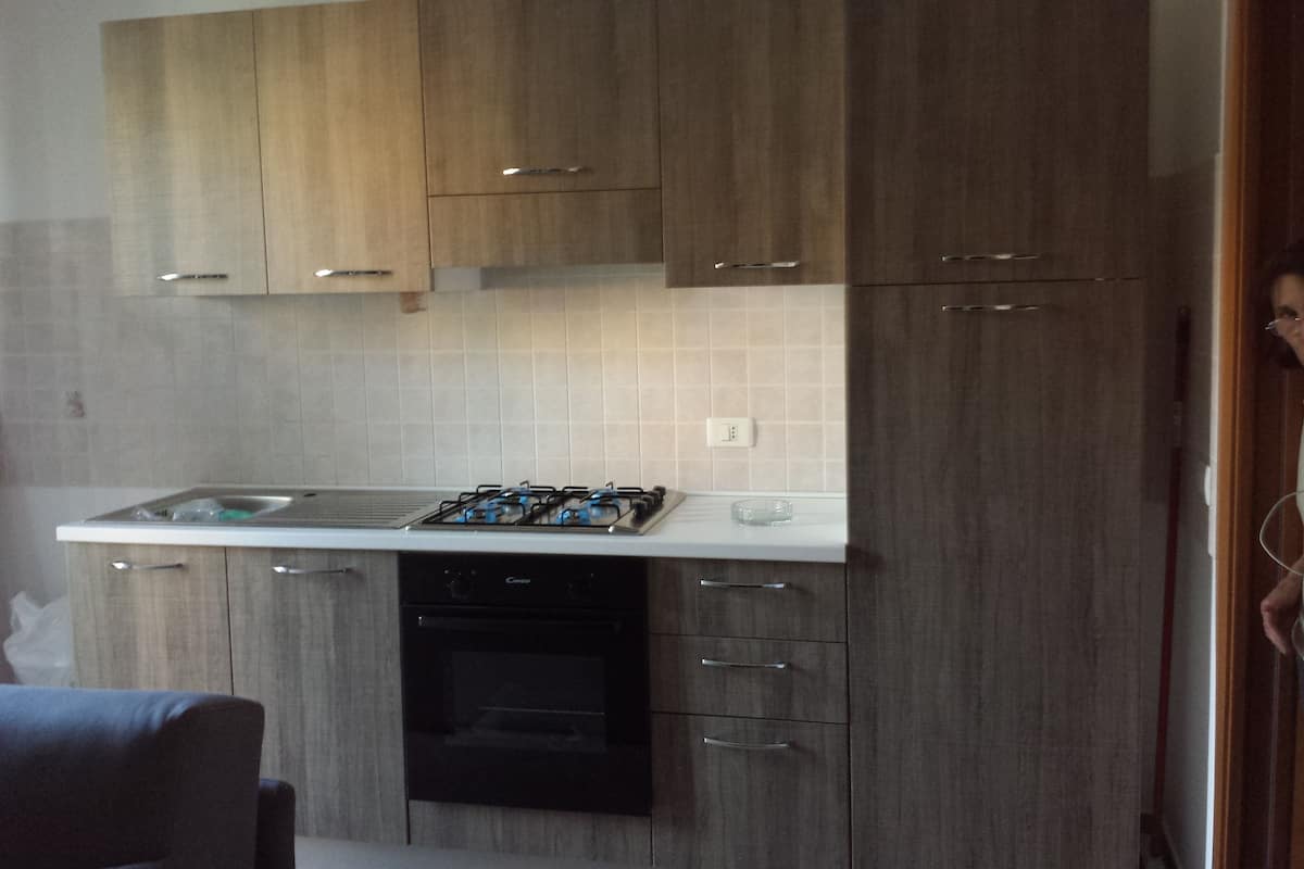 A modern kitchen with wooden cabinets, a gas stove, and a dishwasher.