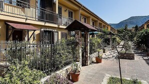 A yellow building with balconies, a brick pathway, and potted plants. - Bed & Breakfast Marina D'Aspra (Bagheria)