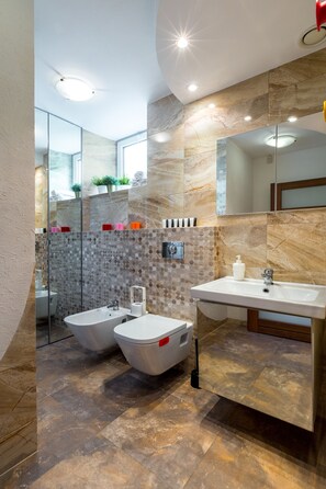 A modern bathroom with a glass shower enclosure, a white sink, and a marble-tiled floor. - FriendHouse Apartments - Wawel Old City (Kraków)