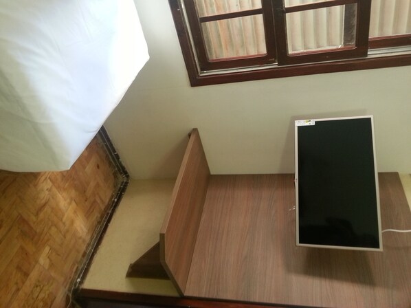 A room with a bed, a wooden desk, and a window with blinds. - Aurora Hotel (Ribeirão Preto)