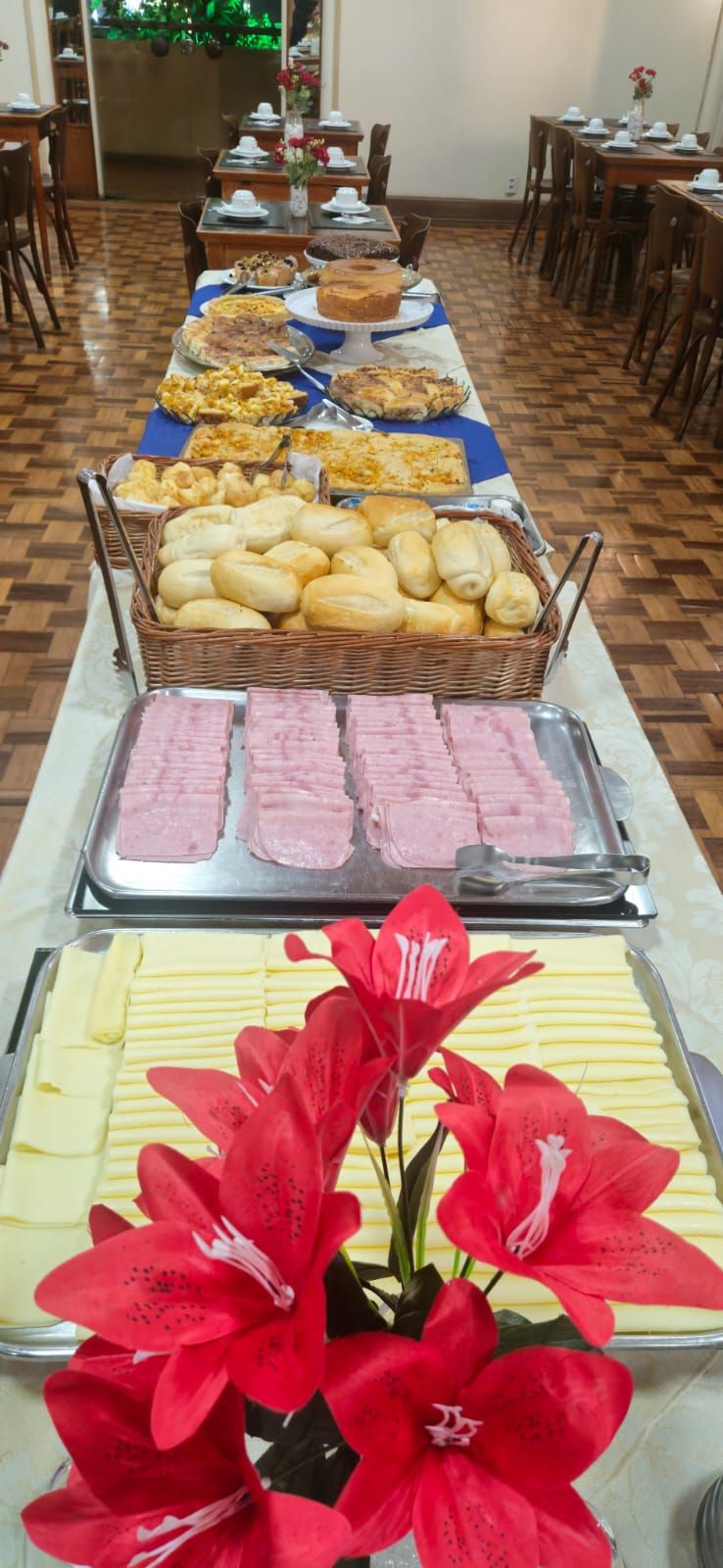 A buffet with various food items and a decorative flower arrangement.