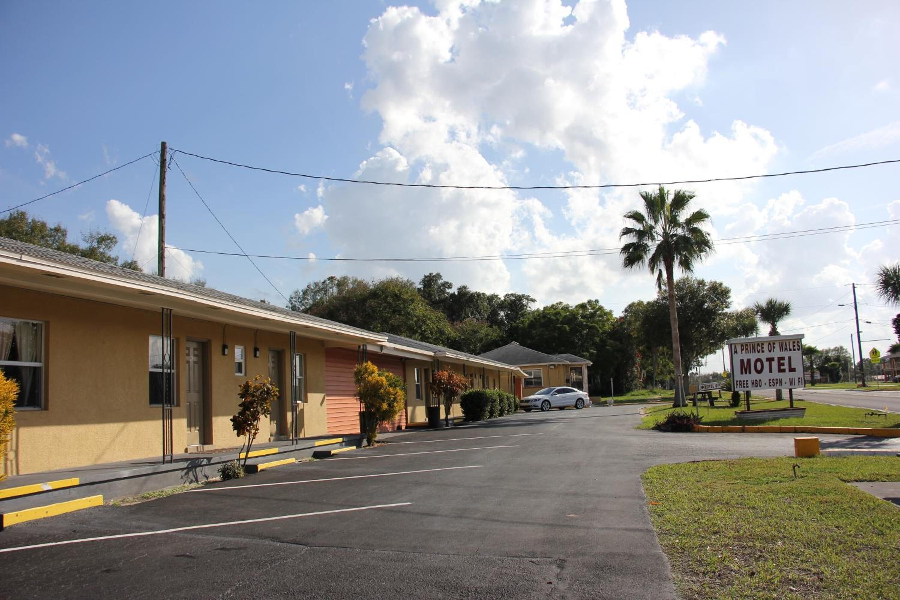 A motel with a sign indicating amenities like free HBO, ESPN, and WiFi.