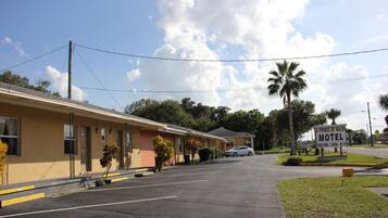 A motel with a sign indicating amenities like free HBO, ESPN, and WiFi.