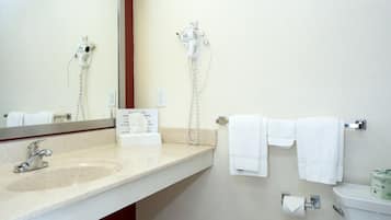 Une salle de bain équipée d’un lavabo, d’un miroir, d’un porte-serviettes et de toilettes.