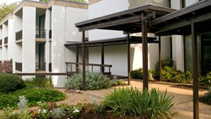 A modern building with a covered outdoor area, surrounded by landscaped gardens. - Griffin Hotel, an official Colonial Williamsburg Hotel (Williamsburg)