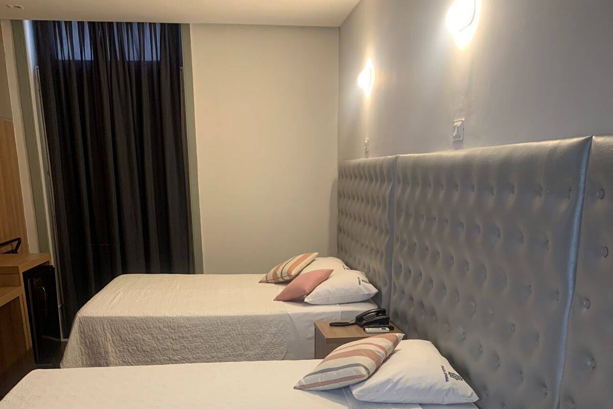 Two single beds with headboards, a bedside table, and a lamp.
