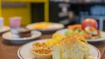 Uma mesa de jantar com pratos de comida, incluindo um croissant e uma torta.