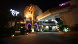 Un motel moderno con una entrada circular llamativa y un letrero de neón.