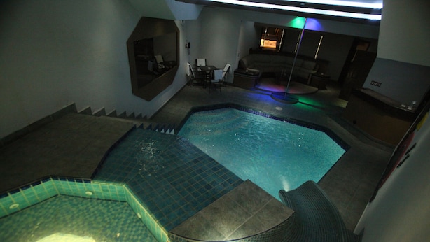 Una piscina con hidromasaje y un área de estar con mesa y sillas.