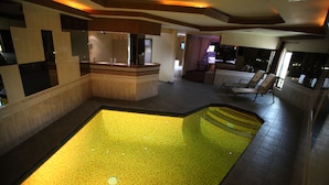 Amplio espacio interior con piscina central, zona de estar y mostrador de recepción.