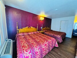 Una habitación con dos camas, un calentador y una lámpara fijada a la pared.