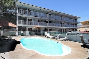 Un motel à plusieurs étages doté d’une piscine, d’un espace extérieur aménagé et d’un parking.