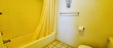 Ein kleines Badezimmer mit einer Badewanne, Toilette und einer Duschvorhang.