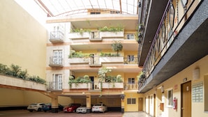 A multi-level parking garage with cars parked on the ground floor. - Hotel Santa María (Mexico City)