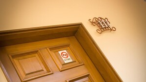 A wooden door with a "No Parking" sign and a decorative wall-mounted item above it. - Hotel Santa María (Mexico City)