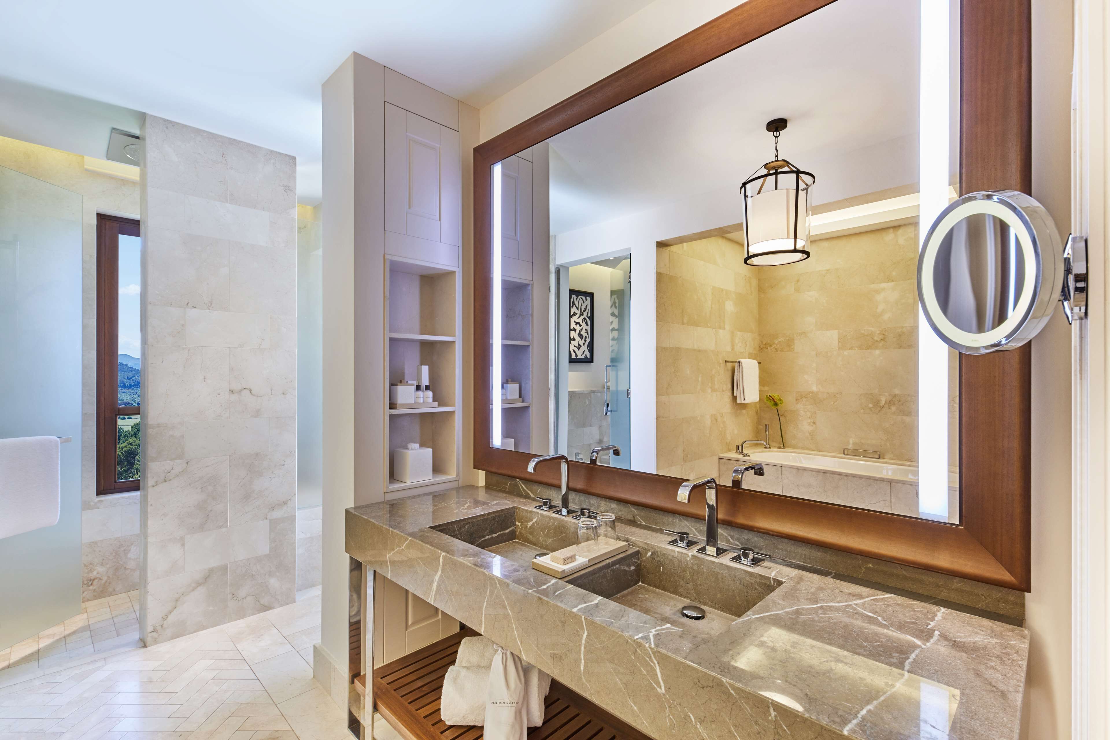A modern bathroom with a large mirror, two sinks, and a vanity.