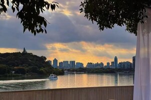 Un río con un bote, un horizonte urbano de fondo y una cubierta de madera.