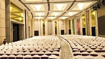 A large, circular auditorium with rows of white chairs and a central aisle.