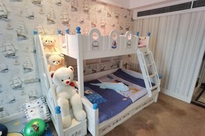 Ein Etagenbett mit einer Leiter, ein Teddybär und eine Schiffstapete.