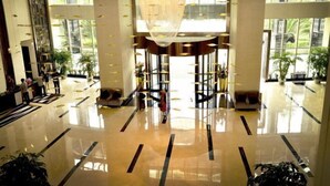 A spacious lobby with a polished floor, large windows, and a central decorative element.