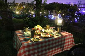 An outdoor dining setup with a checkered tablecloth, a lantern, and a variety of food items. - Mianyang Fulin Taohuadao Hotel (Mianyang)