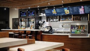 Un restaurant moderne doté d’un bar, de chaises en bois et d’un présentoir pour afficher le menu.