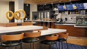 Un intérieur de restaurant moderne avec un bar, des éléments décoratifs en bois et un présentoir pour afficher le menu.