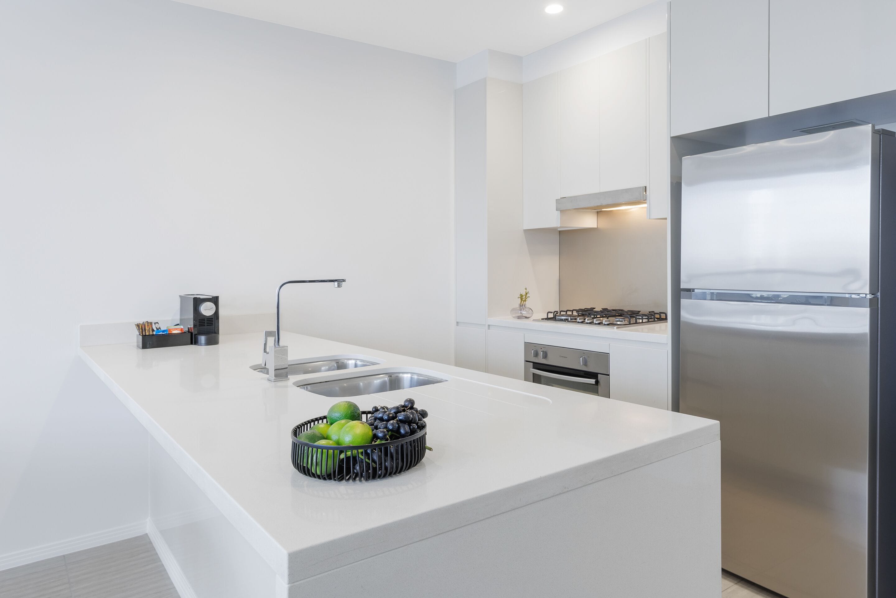 Una cucina moderna con isola centrale, elettrodomestici in acciaio inossidabile e un design pulito e minimalista.