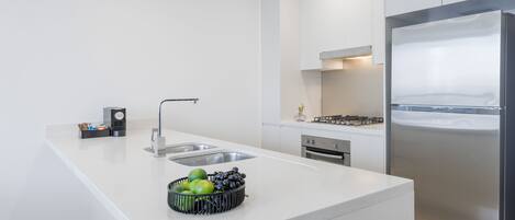 A modern kitchen with a central island, stainless steel appliances, and a clean, minimalist design.