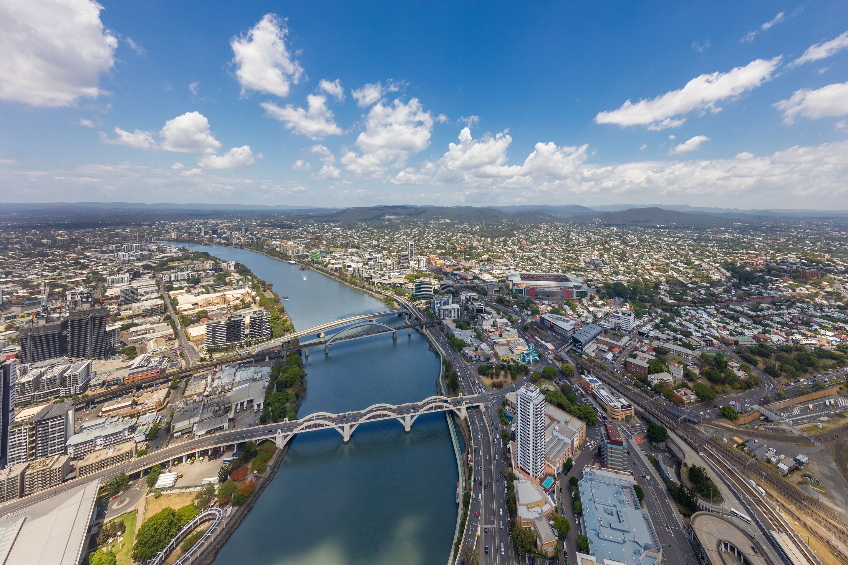 An aerial view of a city with a river, bridges, and dense urban development.