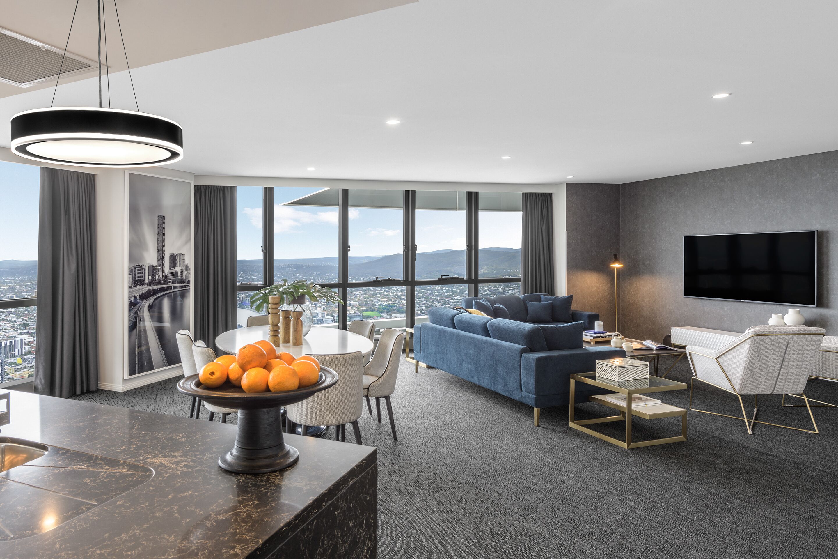 Una sala de estar moderna con vistas a la ciudad, un comedor y un televisor de pantalla plana.