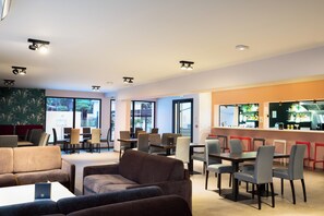 A modern cafe with seating arrangements, a bar area, and large windows providing natural light. - Sowell Residences Les Chenes Verts (Saint-Raphael)