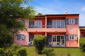 A two-story house with a balcony, a door with shutters, and a small garden area. - Sowell Residences Les Chenes Verts (Saint-Raphael)
