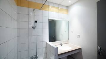 Un bagno moderno con box doccia in vetro, un lavabo con specchio e pareti piastrellate.