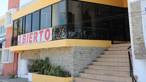 A building with a sign reading "Brava" and "ABIERTO" indicating it is open. - Hotel Costa Brava (Manzanillo)