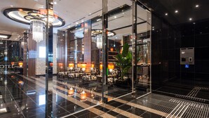 A modern hotel lobby with a glass partition, seating area, and a reception desk. - APA Hotel Sugamo Ekimae (Tokyo)