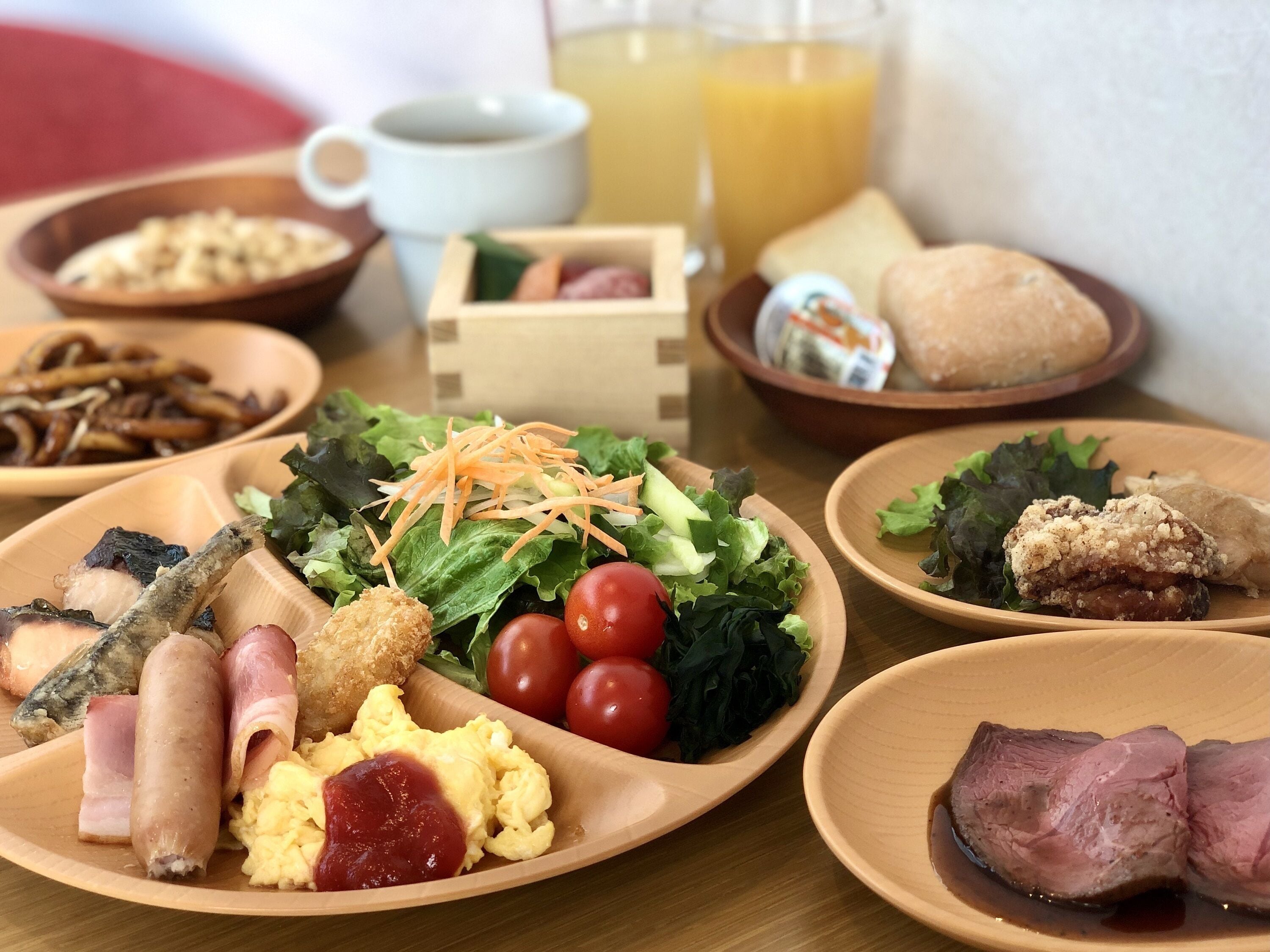 Un assortiment de plats variés pour le petit-déjeuner, comprenant des œufs, des saucisses et des légumes.