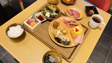 A meal tray with various dishes including rice, sashimi, salad, and meats.