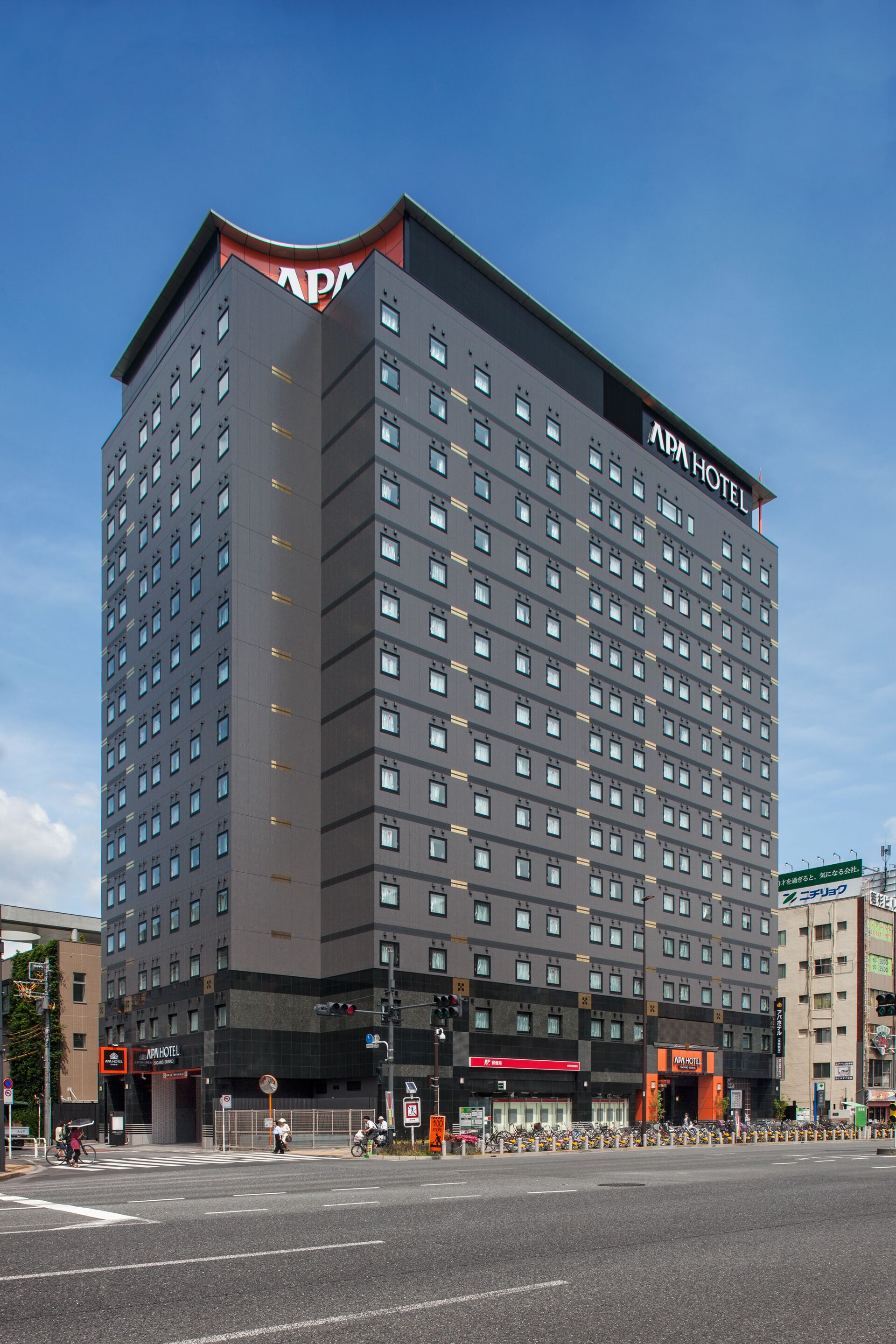 A multi-story hotel with a modern architectural design, featuring numerous windows and a prominent signage indicating it is an "APM Hotel".