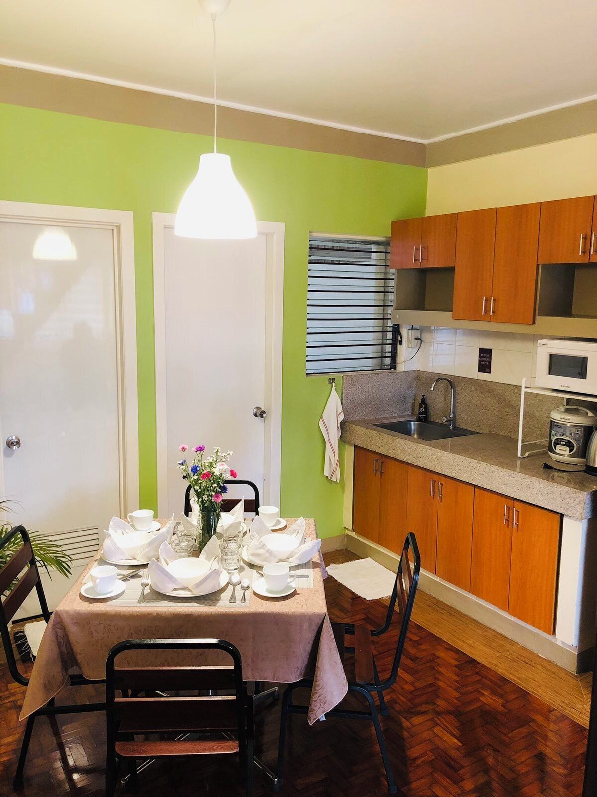 A compact kitchen with wooden cabinets, a microwave, and a sink.