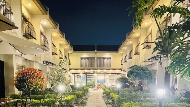 A courtyard with a central pathway leading to a building labeled "Baguio Holiday Villas." - Baguio Holiday Villas (Baguio)