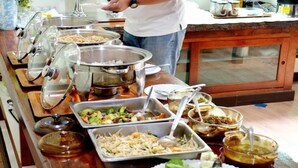 A buffet setup with various food items and serving utensils. - Baan Na Khon Hotel (Nakhon Si Thammarat)