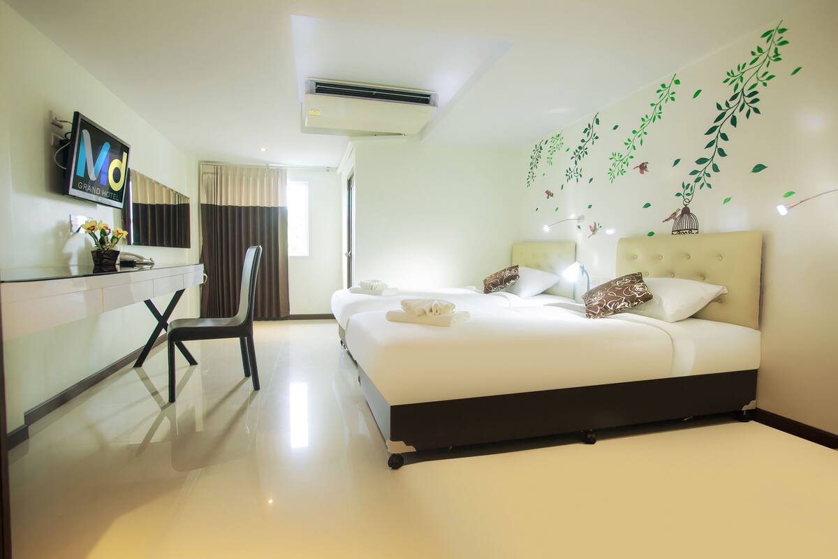 Una habitación de hotel con cama, escritorio, silla y televisor.