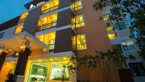 Um hotel com vários andares, varandas, entrada de vidro e uma placa com a inscrição 'De Ville'.