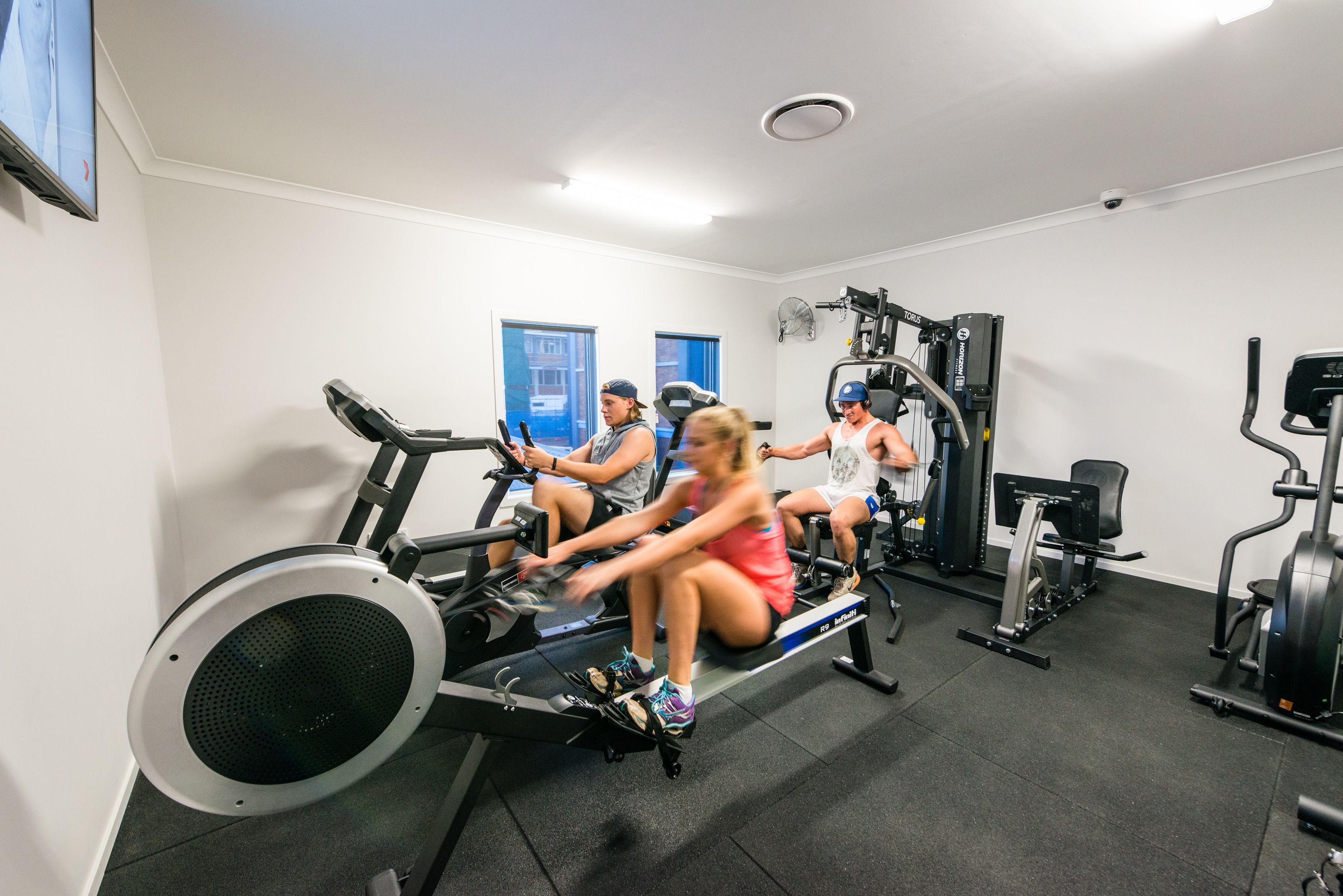 A gym with stationary bikes, weight machines, and a treadmill.